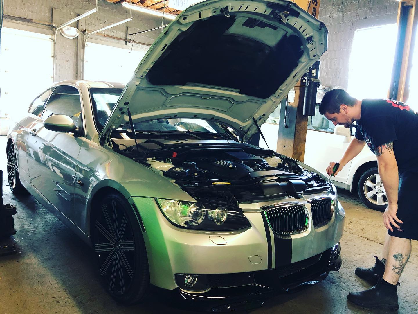 Technician working on BMW headlight at European auto repair shop